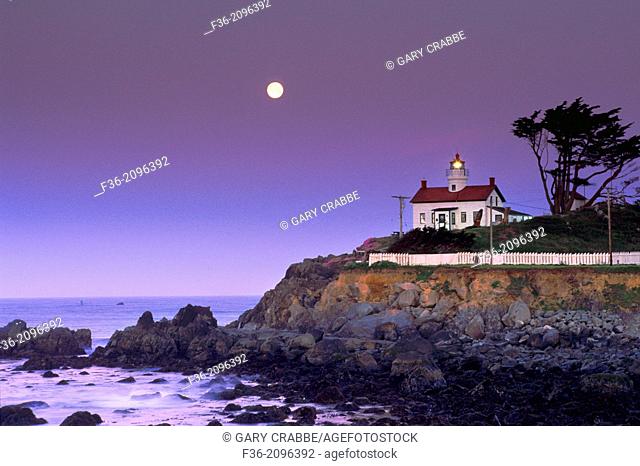 Full moon setting at dawn over Battery Point Lighthouse, Crescent City, Del Norte County, California