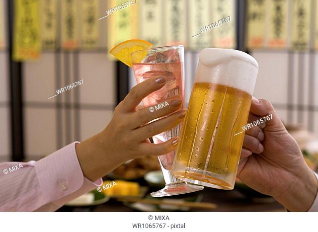 Two People Toasting with Beer and Cocktail at Izakaya