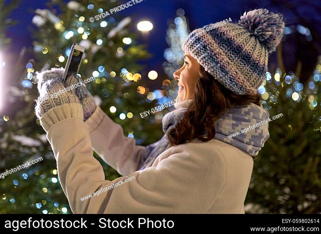 woman with smartphone taking christmas selfie