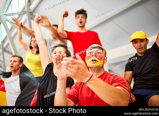 Young fans cheering at sports event in stadium