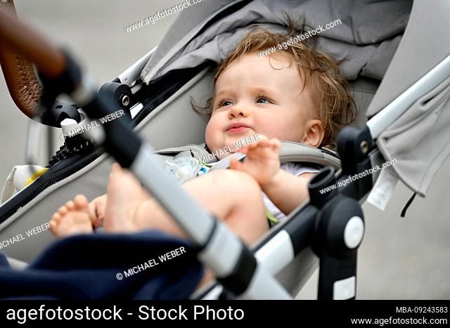 Baby, 8 months, lying in the stroller, Baden-Wuerttemberg, Germany