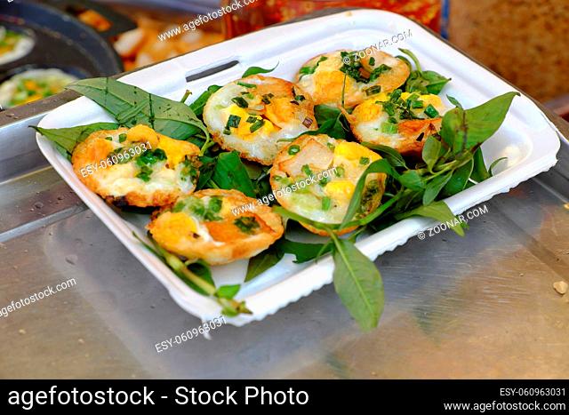 Vietnamese street food, yellow and delicious pancakes on plate at cuisine fair at Ho Chi Minh city, Vietnam, cakes make from rice flour, egg
