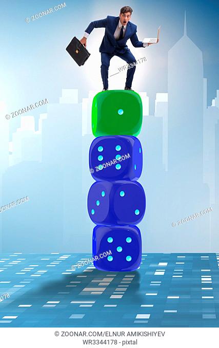 Businessman balancing on top of dice stack in uncertainty concept
