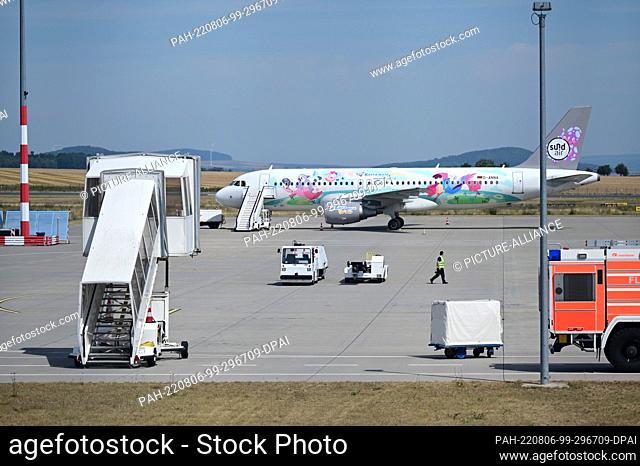 PRODUCTION - 04 August 2022, Hessen, Calden: An airport employee walks across the apron. Staff shortages, strikes, flight cancellations: While chaos currently...