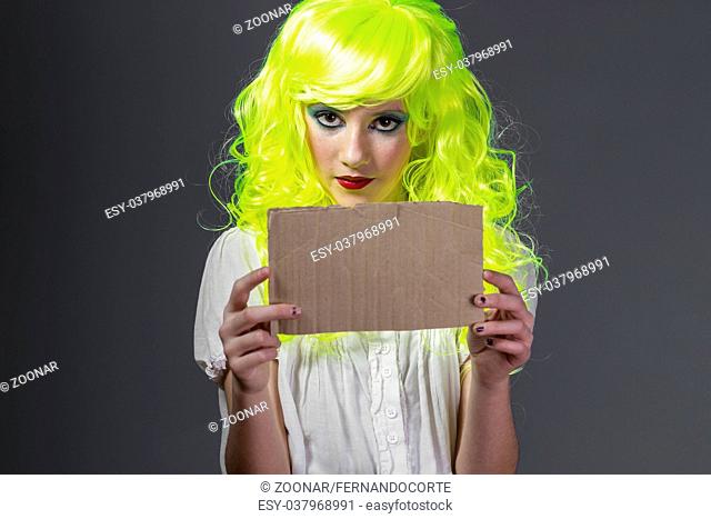 fun, teenager with fluorescent yellow wig, carrying a cardboard write message