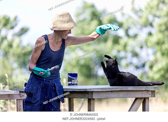 Mature woman playing with cat