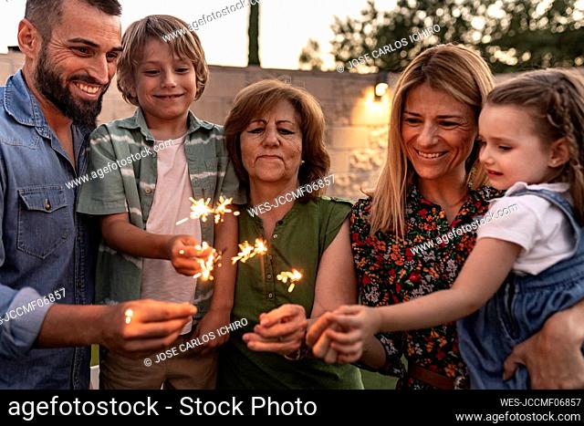 Smiling family burning sparklers together