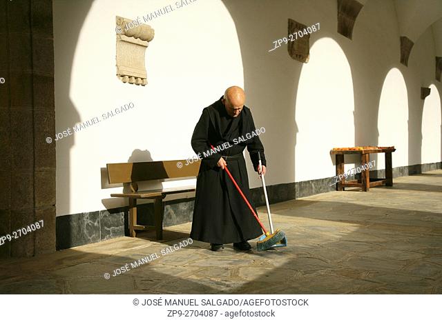 Benedictine monk sweeping in the cloister of the monastery of Samos, Lugo, Spain