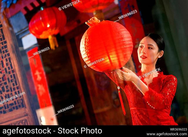 The young woman hangs red lanterns