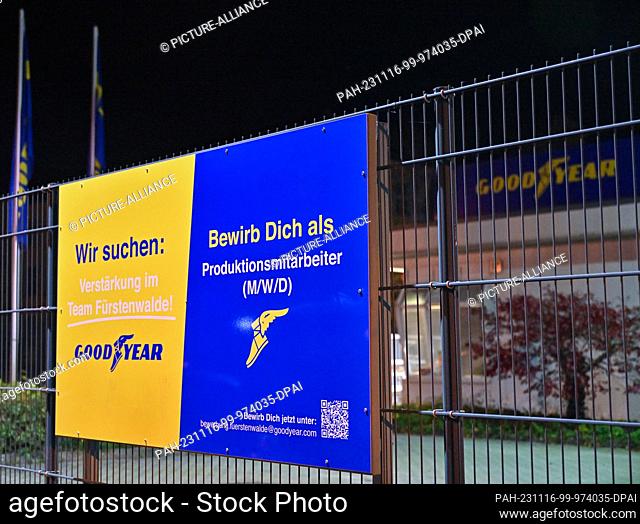 16 November 2023, Brandenburg, Fürstenwalde: In the evening, an advertisement for the reinforcement of the Goodyear team hangs on the fence of the factory...