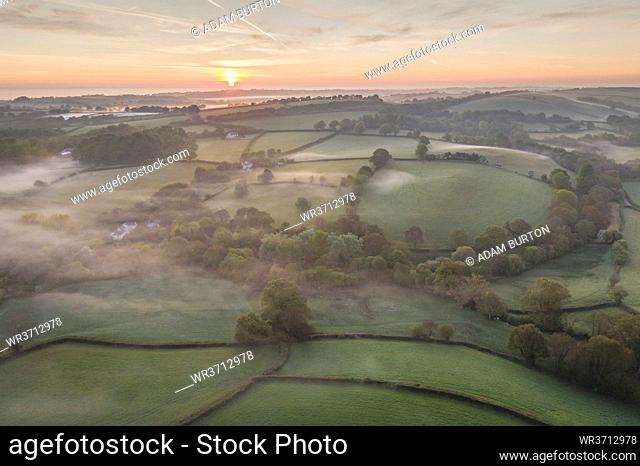 Misty spring sunrise over rolling countryside, South Tawton, Devon, England, United Kingdom, Europe