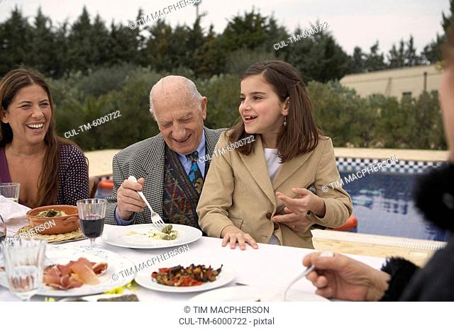 Three generation family eating outdoors