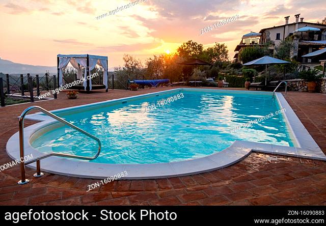 Luxury country house with swimming pool in Italy. Pool and old farm house during sunset central Italy