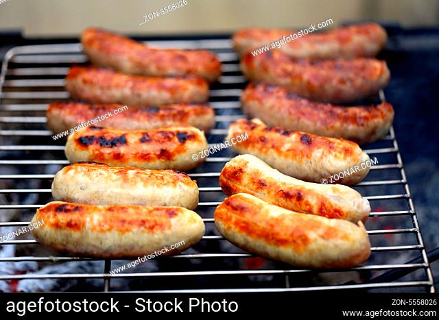 Sausages on grill on a whole background
