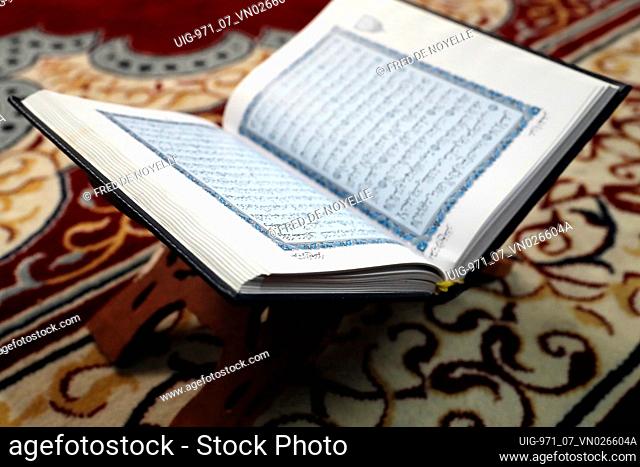 An open Holy Quran in arabic on wood stand