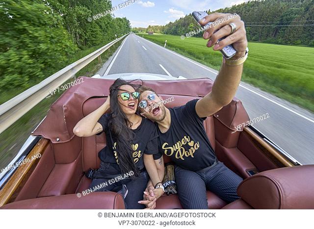 adventurous couple taking selfie while driving in luxury oldtimer. Turkish ethnicity. High society. Bloggers Adem Bayalan and Emine Feruz Bayalan
