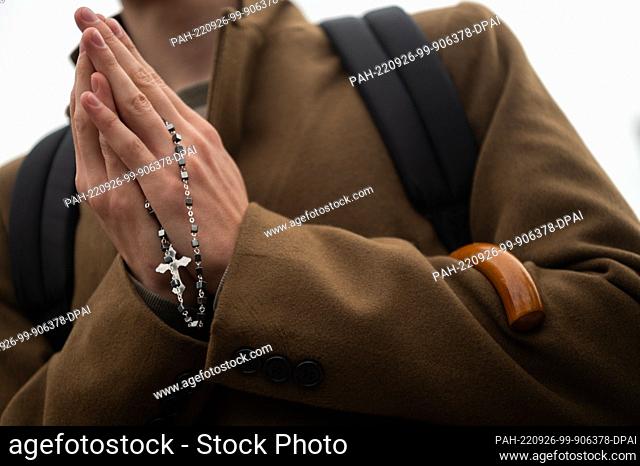 26 September 2022, Hessen, Fulda: An activist of the conservative Catholic initiative Maria 1.0 prays a rosary in front of the Fulda City Palace at the...