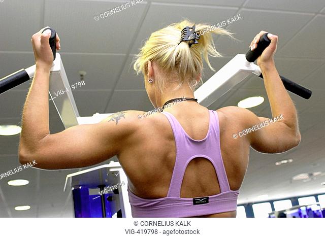 Woman is exercising weight training within a gym  - Geesthacht, Schleswig-Holstein, GERMANY, 06/04/2007