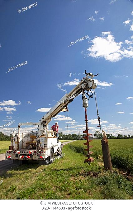 Dundee, Michigan - Electrical workers remove the remains of a utility pole destroyed by a tornado so they can replace it with a new pole