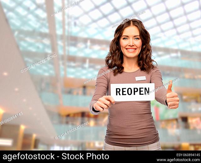 shop assistant with reopen sign showing thumbs up