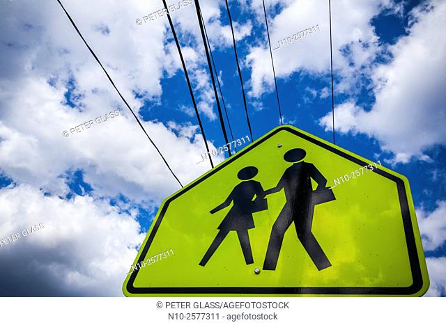 Children crossing sign against a cloudy sky