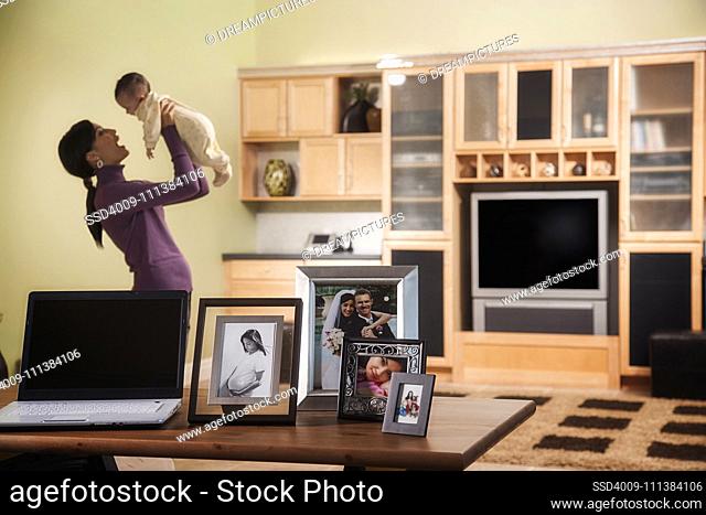 Mother holding baby in living room