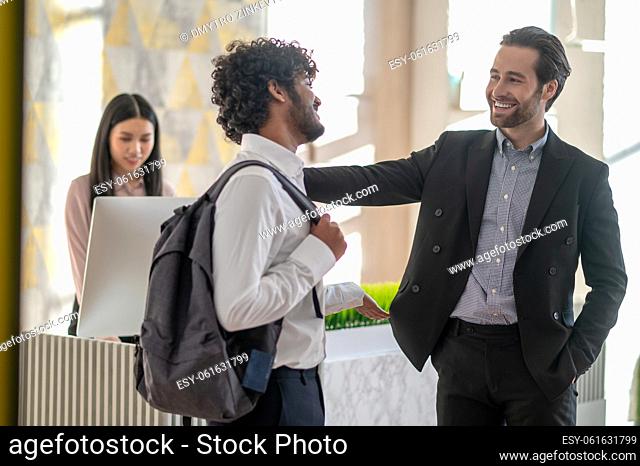 In the business center. Manager welcoming a new employee near reception in the business center