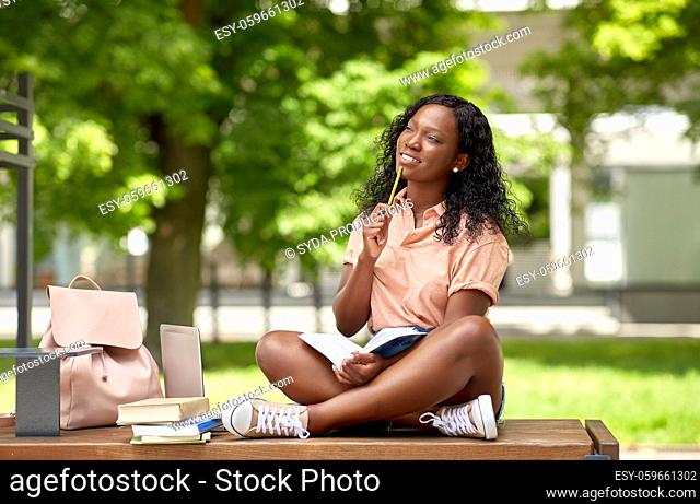 happy african student girl with book in city