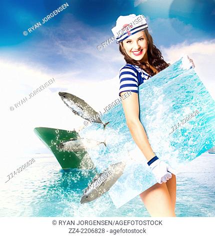 Creative portrait of a gorgeous young navy pin up model having fun while holding a tropical sea board with fish jumping through