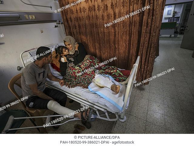 dpatop - Palestinian woman Asma Abu Daqah (R) and her husband Mohammed Abu Daqah (L) lie inside a hospital with their daughter Lian after being injured during...