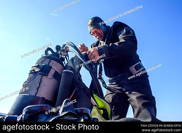 28 September 2023, Saxony-Anhalt, Arendsee: Diver Andreas Trepte prepares for a dive on a boat on Lake Arendsee. Archaeologists from the Saxony-Anhalt State...