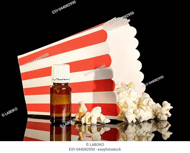 Aromatic liquid for smoking an electronic cigarette, and box of popcorn isolated on black background