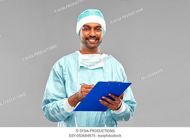 indian male doctor or surgeon with clipboard