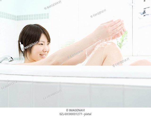 Woman Listening to Music in Bathtub