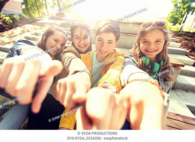 teenage friends or students pointing finger at you