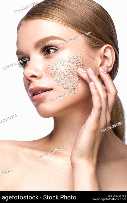 Beautiful young girl with scrub on the skin and French manicure. Beauty face. Picture taken in the studio on a white background