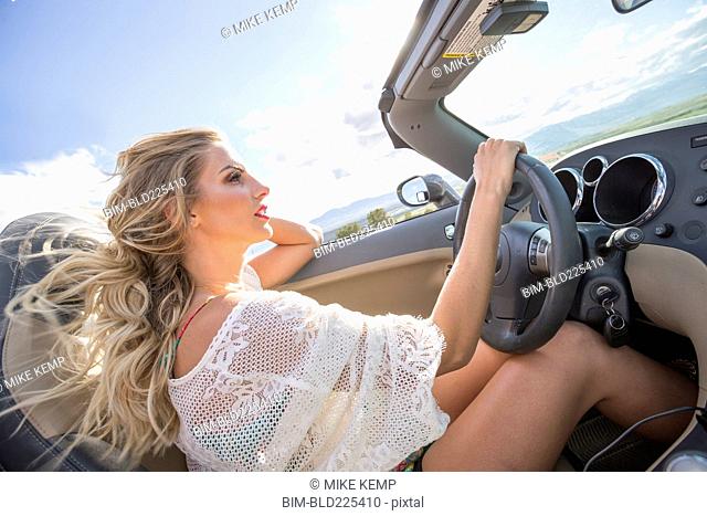 Caucasian woman driving in sports car