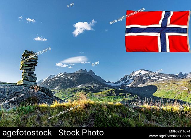 Mountain landscape with stone pyramid in Jotunheimen with Norwegian flag