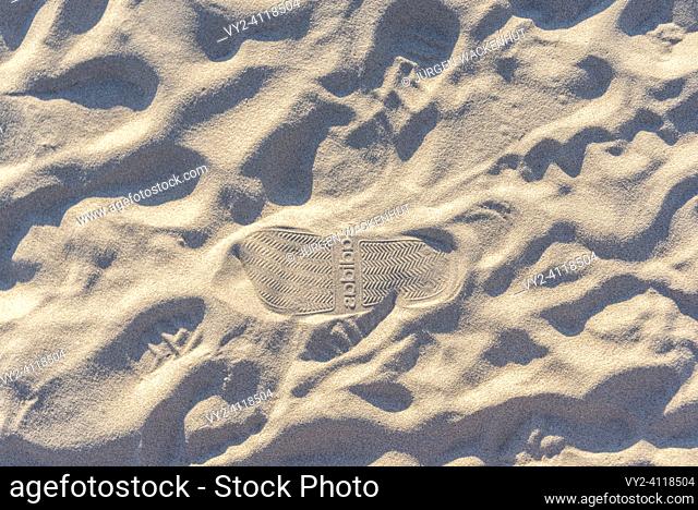 Footprints in the sand with the Adidas brand logo