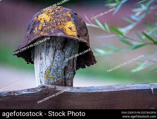 19 September 2023, Mecklenburg-Western Pomerania, Jamel: A rusty steel helmet hangs on the garden fence in front of the house of Krüger