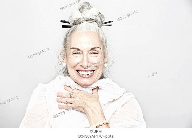 Studio portrait of sophisticated senior woman laughing