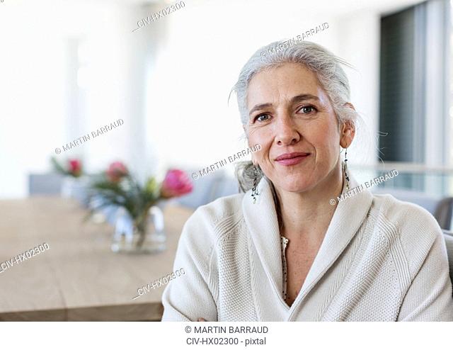 Portrait mature woman sitting at dining table