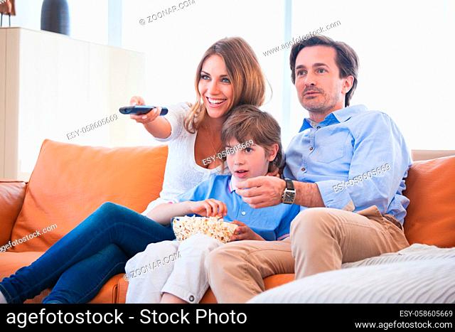 Happy family of Father, mother and boy watching TV at home