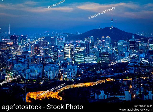 Seoul downtown cityscape illuminated with lights and Namsan Seoul Tower in the evening view from Inwang mountain. Seoul, South Korea