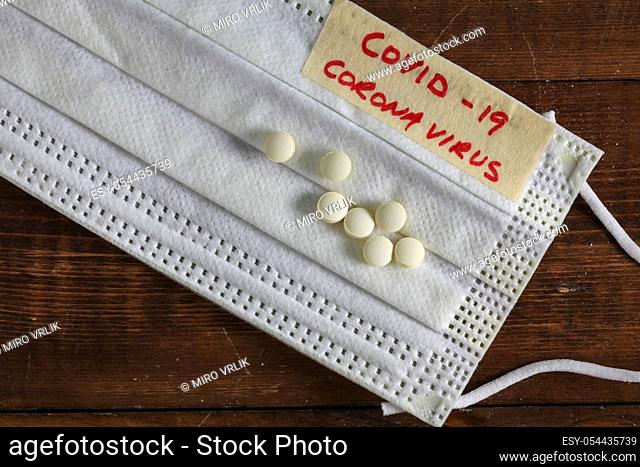 Medical protective mask Corona virus alias covid-19 on wooden background with pills