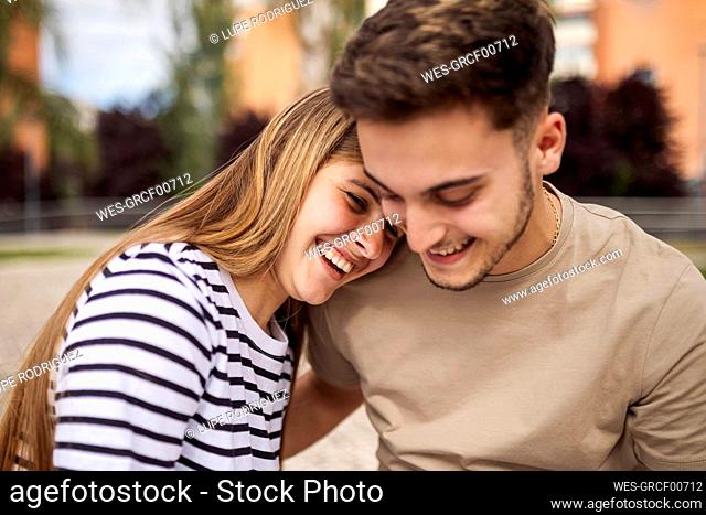 Smiling girlfriend with head on shoulder of boyfriend