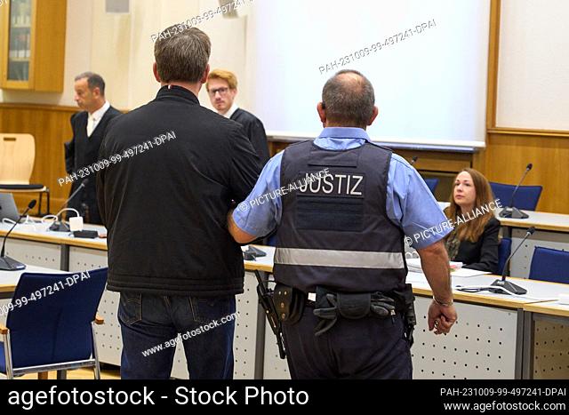 09 October 2023, Rhineland-Palatinate, Koblenz: The defendant (front left) is led into the courtroom of the Higher Regional Court for the announcement of the...