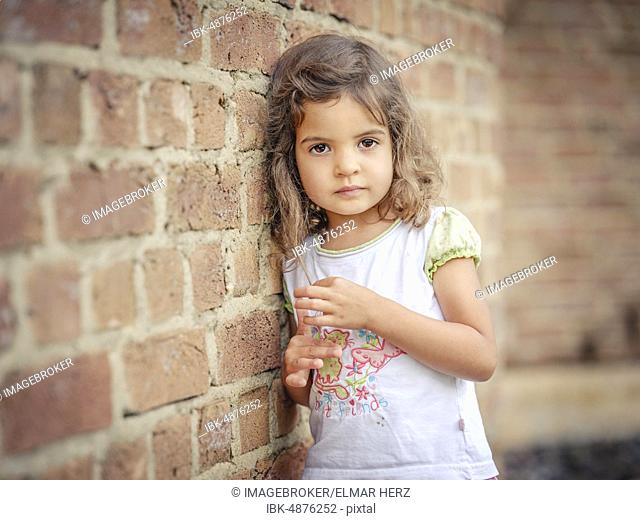 Girl, 3 years old, leaning against a wall, portrait, Germany, Europe