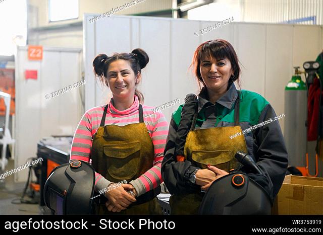 portrait of two welders holding welding masks in their hands and preparing for hard work in a factory. High quality photo