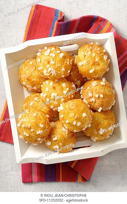 Chouquettes with crystal sugar on a wooden tray
